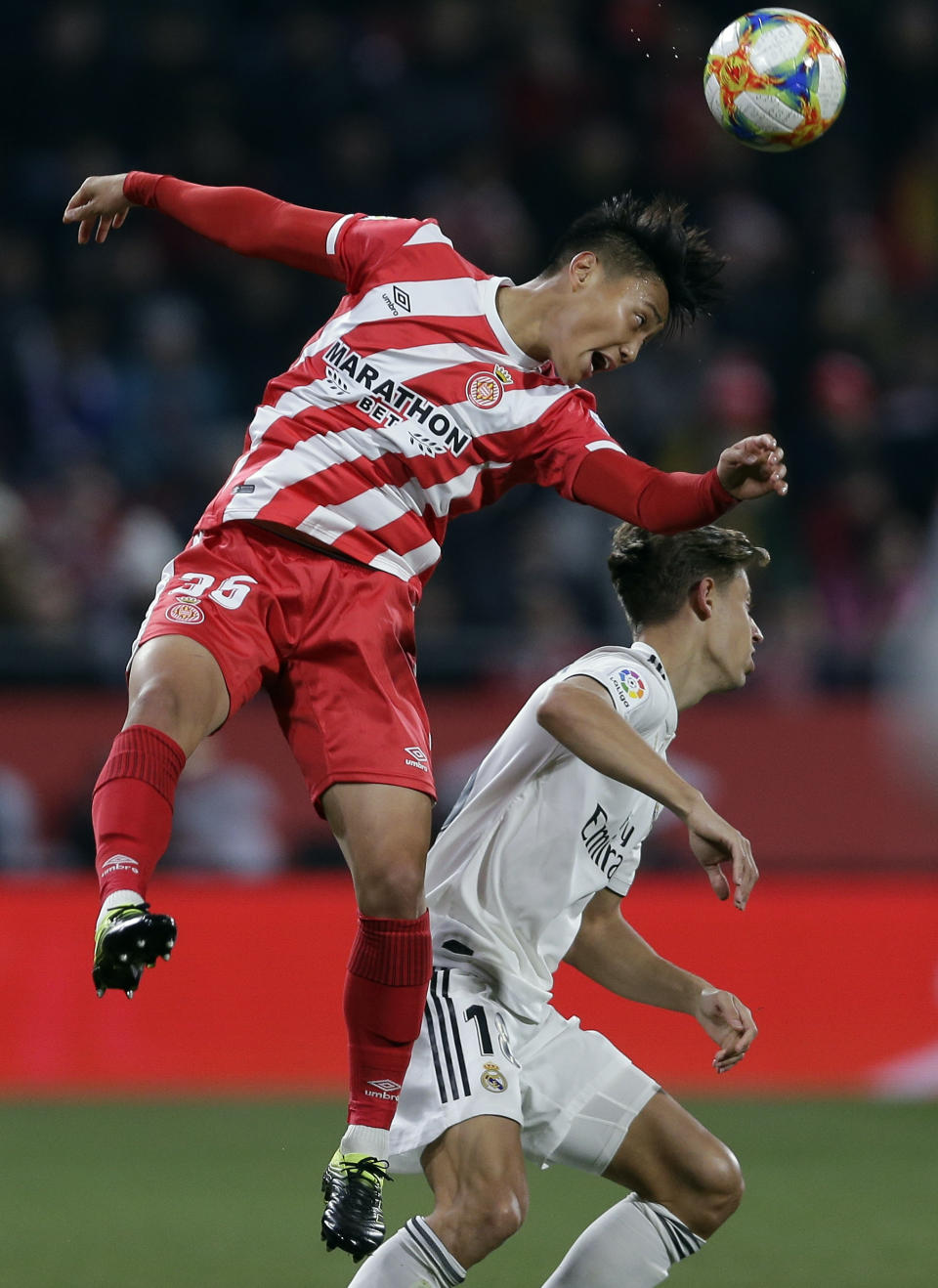 Real Madrid's Marcos Llorente, right, duels for the ball with Girona's Paik Seung-ho during a Spanish Copa del Rey soccer match between Girona and Real Madrid at the Montilivi stadium in Girona, Spain, Thursday, Jan. 31, 2019. (AP Photo/Manu Fernandez)