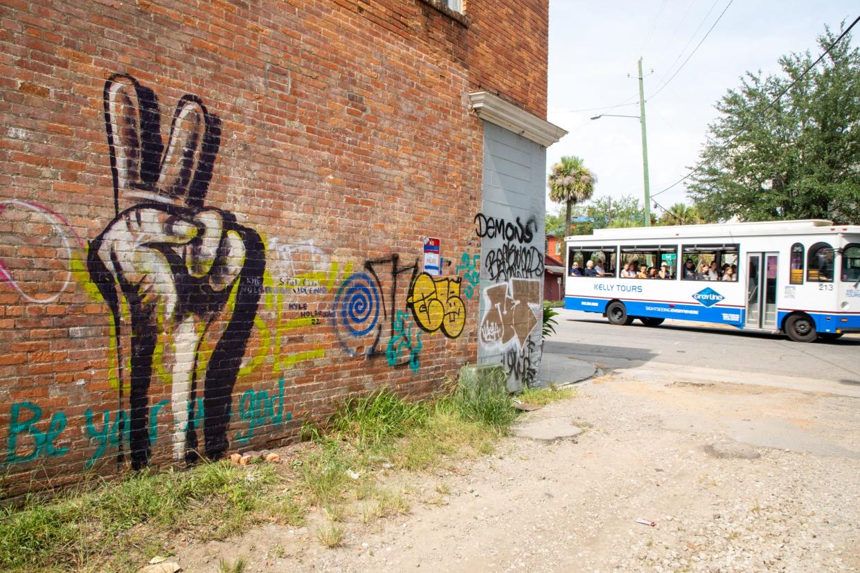 A tour bus drives down Bull Street next to Kyle Holbrook's recently completed mural memorializing those lost to gun violence on Aug. 3, 2022.