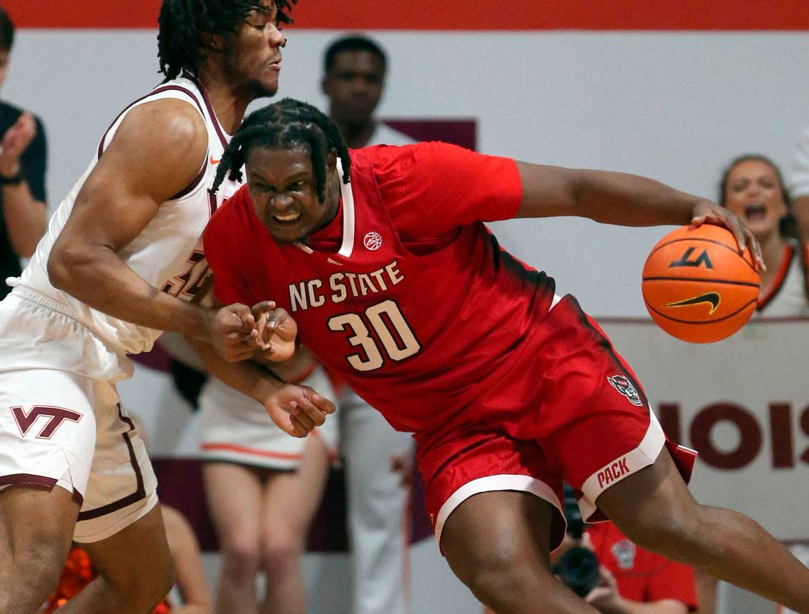 North Carolina State’s DJ Burns, Jr., right, drives on Virginia Tech’s Mylyjael Poteat (34) during the second half of an NCAA college basketball game Saturday, Jan. 7, 2023, in Blacksburg, Va.