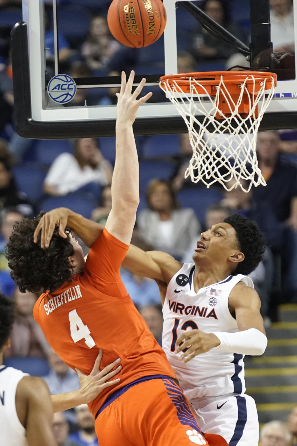 Clemson forward Ian Schieffelin (4) is hit as he shoots against Virginia guard Chase Coleman (12) during the first half of an NCAA college basketball game at the Atlantic Coast Conference Tournament in Greensboro, N.C., Friday, March 10, 2023. (AP Photo/Chuck Burton)