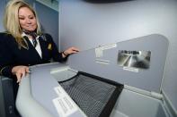 LOS ANGELES, CA - NOVEMBER 30: United Airlines flight attendant Tina Henderson shows the new baby bassinette while touring the new Boeing 787 Dreamliner at Los Angeles International Airport on November 30, 2012 in Los Angeles, California. In January the new jet is scheduled to begin flying daily non-stop between Los Angeles International airport and Japan's Narita International Airport and later to Shanghai staring in March. The new Boeing 787 Dreamliner will accommodate 219 travelers with 36 seat in United Business First, 70 seats in Economy Plus and 113 in Economy Class. The carbon-fiber composite material that makes up more than 50 percent of the 787 makes the plane jet and more fuel-efficient. (Photo by Kevork Djansezian/Getty Images)