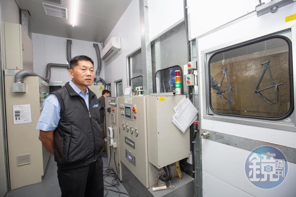 明係遷至彰化大村廠時，江永平（左）買了3台自動化機械手臂取代人工塗裝，讓車架上色更均勻。