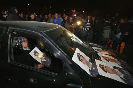 Mother of Islamic State captive Jordanian pilot Muath al-Kasaesbeh holds his picture while sitting in a car, as she takes part in a demonstration demanding that the Jordanian government negotiate with Islamic state and for the release of her son, in front of the prime minister's building in Amman, January 27, 2015. REUTERS/Muhammad Hamed
