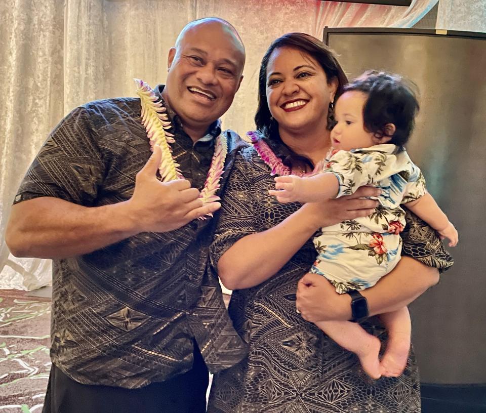 Tua Tagovailoa's parents, Galu and Diane, pose with their 7-month-old grandchild at the Luau with Tua event Monday night at the Seminole Hard Rock Hotel & Casino.