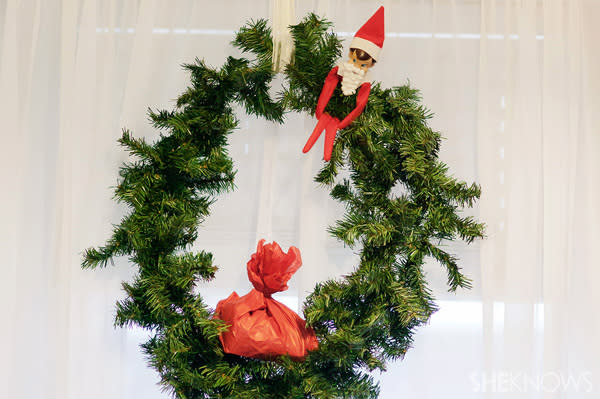 Elf on the Shelf idea 17: Elfie Rojo hides in a wreath