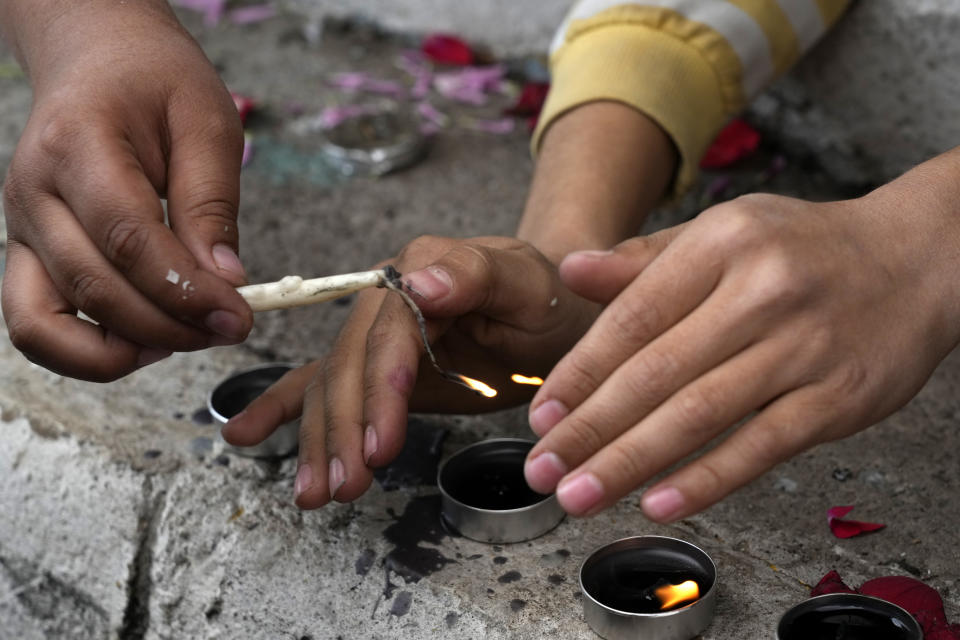 Children light candles at the scene of Wednesday's bomb explosion in the city of Kerman, about 510 miles (820 kms) southeast of the capital Tehran, Iran, Thursday, Jan. 4, 2024. Investigators believe suicide bombers likely carried out an attack on a commemoration for an Iranian general slain in a 2020 U.S. drone strike, state media reported Thursday, as Iran grappled with its worst mass-casualty attack in decades and as the wider Mideast remains on edge. (AP Photo/Vahid Salemi)