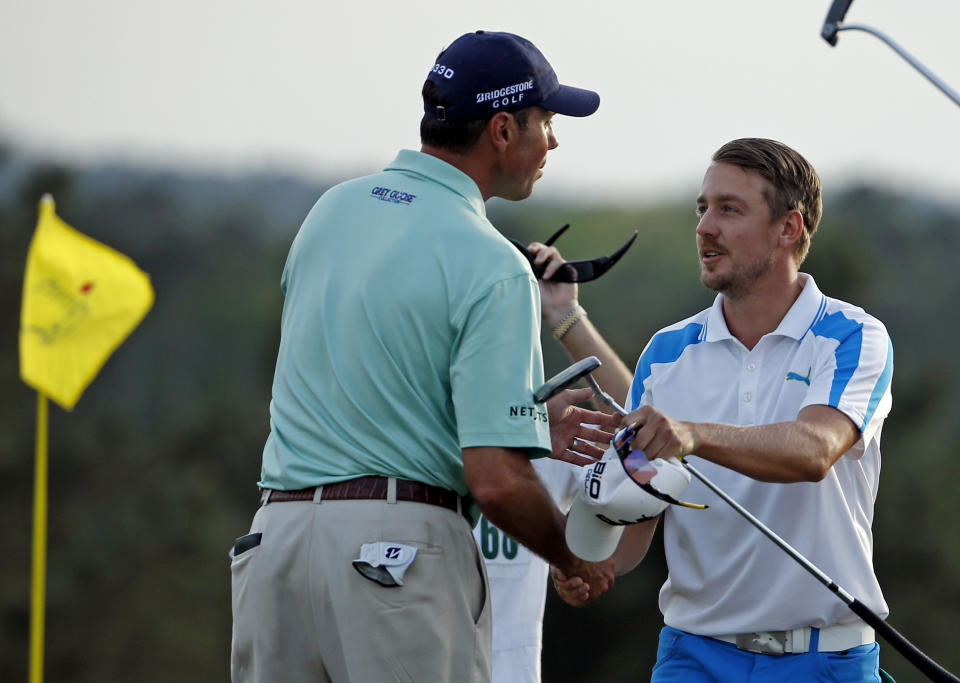 Jonas Blixt, of Sweden, is congratulated by Matt Kuchar, left, on the 18th green following their fourth round of the Masters golf tournament Sunday, April 13, 2014, in Augusta, Ga. (AP Photo/Matt Slocum)