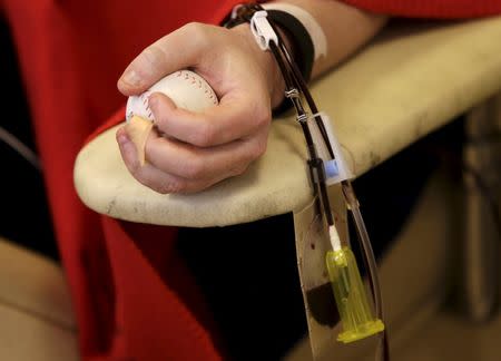 Bill Myers of Washington squeezes a small rubber ball while having blood platelets drawn at the American Red Cross Charles Drew Donation Center in Washington February 16, 2016. REUTERS/Gary Cameron
