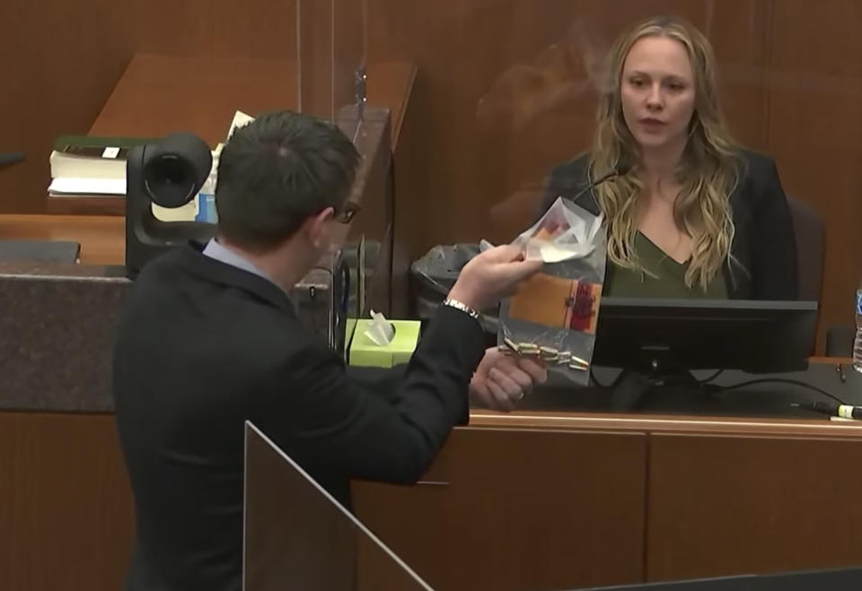 In this screen grab from video, Assistant Attorney General Joshua Larson shows evidence to Melissa Loren, a forensic scientist with the Bureau of Criminal Apprehension as she testifies, as Hennepin County Judge Regina Chu presides over court Monday, Dec. 13, 2021, in the trial of former Brooklyn Center police Officer Kim Potter in the April 11, 2021, death of Daunte Wright, at the Hennepin County Courthouse in Minneapolis, Minn. (Court TV via AP, Pool)