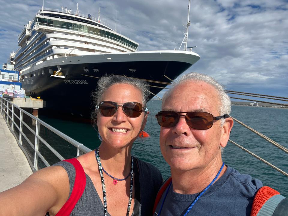 rebecca and her husband posing with holland america cruise ship