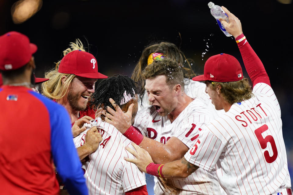 Philadelphia Phillies' Jean Segura celebrates with his teammates after hitting a game-winning RBI-single against Miami Marlins pitcher Tommy Nance during the ninth inning of a baseball game, Tuesday, Sept. 6, 2022, in Philadelphia. (AP Photo/Matt Slocum)