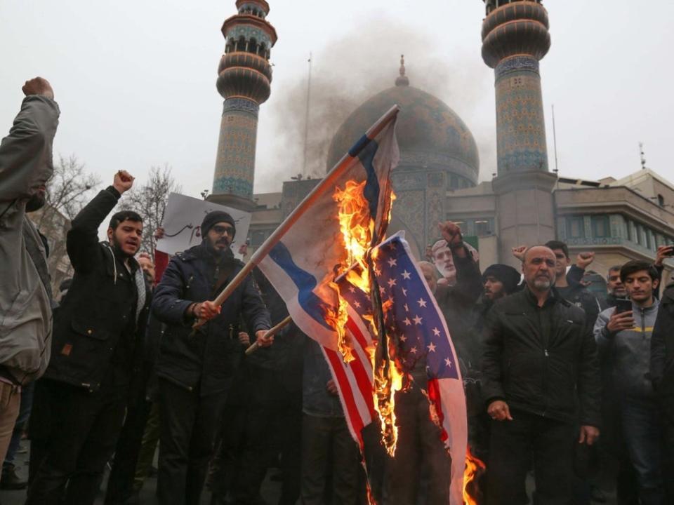 <p>Iranians burn US and Israeli flags following the assassination</p>AFP/Getty