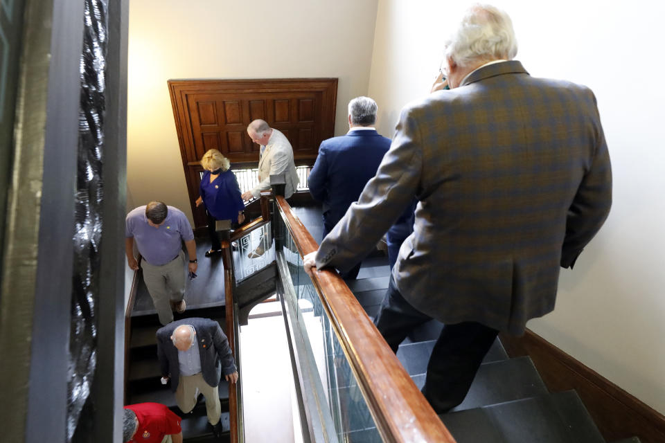 FILE - In this June 27, 2020, file photo, Republican members of the House walk to the Ways and Means conference room to caucus, at the Capitol in Jackson, Miss. Mississippi is seeing the largest outbreak of COVID-19 among legislators in any state. (AP Photo/Rogelio V. Solis, File)