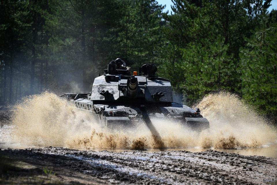 A member of the British army drives a tank as he takes part in a training session of British forces and Challengers tanks at the Ministry of Defence (MOD) training base in southern England on August 15, 2023.