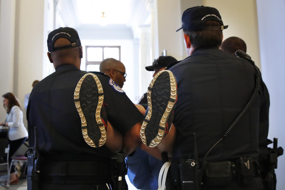 <p>The soles of a man’s sneakered feet are seen as he is removed by Capitol Police from a sit-in of Senate Majority Leader Mitch McConnell’s office, as he and others protest proposed caps to Medicaid Thursday, June 22, 2017, on Capitol Hill in Washington. (Photo: Jacquelyn Martin/AP) </p>