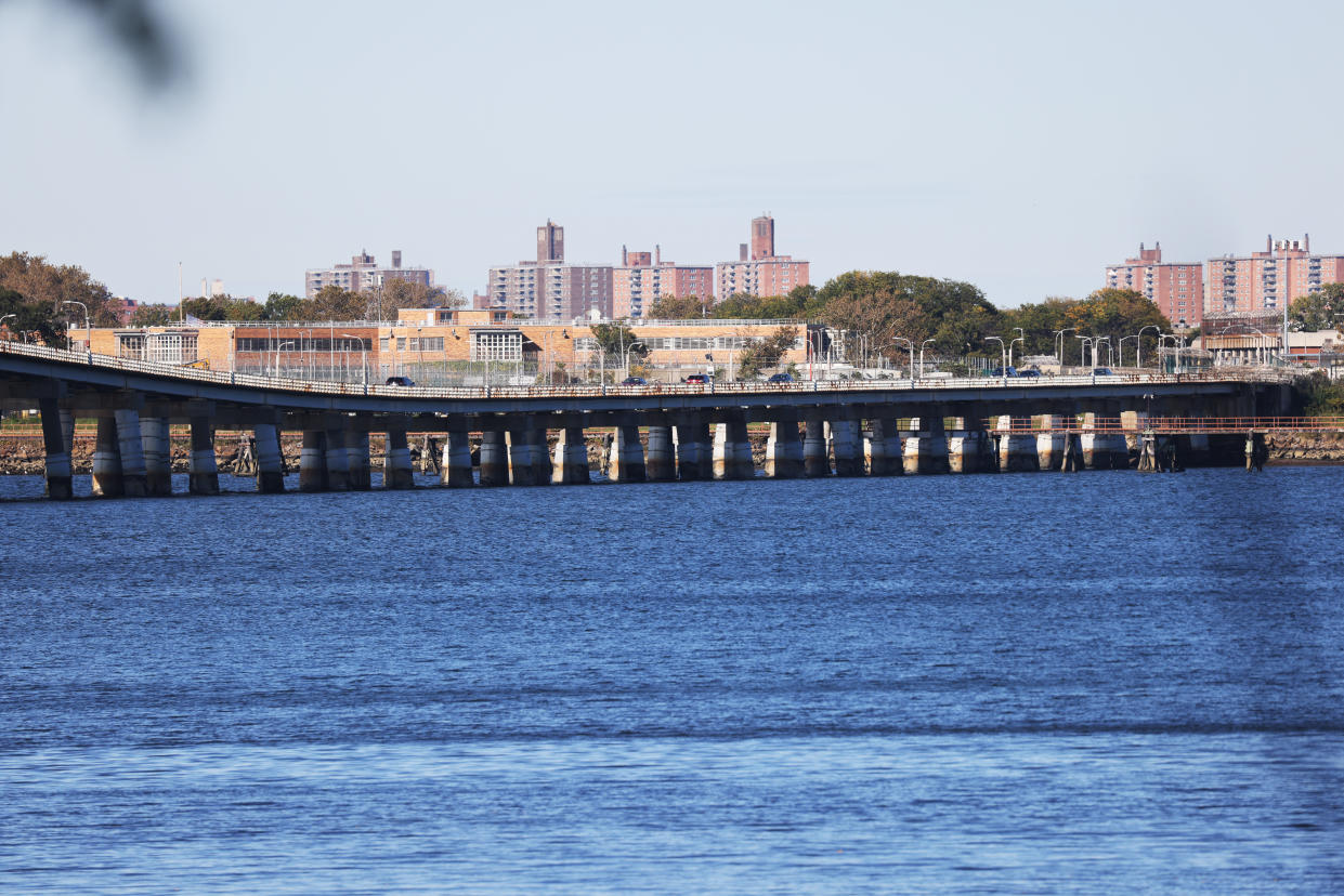 A distant view of the Rikers Island jail complex, with water in the foreground, on Rikers Island in the East River between Queens and the Bronx in New York City. 