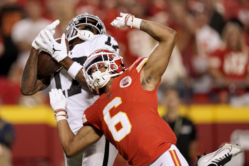 Las Vegas Raiders wide receiver Davante Adams, left, catches a 48-yard touchdown pass as Kansas City Chiefs safety Bryan Cook (6) defends during the second half of an NFL football game Monday, Oct. 10, 2022, in Kansas City, Mo. (AP Photo/Charlie Riedel)