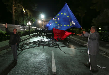 A man waves an EU and an Albanian flag during an anti-government protest in front of the Parliament in Tirana, Albania, May 25, 2019. REUTERS/Florion Goga