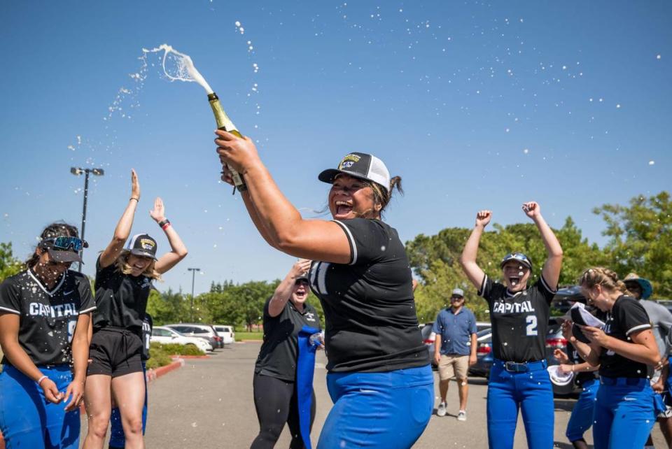 Capital Christian Cougars Nani Lose-Mahina (21) celebrates with sparkling cider and her teammates after their CIF Sac-Joaquin Section Division IV high school softball championship win over the Dixon Rams on Saturday, May 27, 2023, at Cosumnes River College.