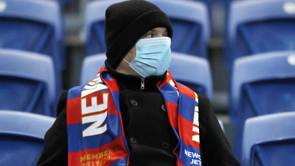 A Newcastle Jets fan, pictured here wearing a face mask during the match against Western United.