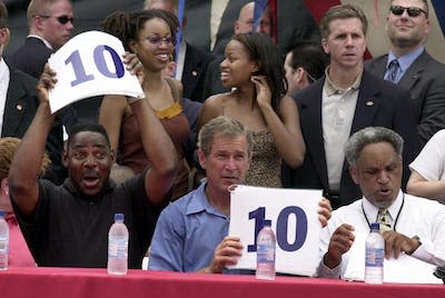 Sometimes players will perform tricks while in the air. <a href="https://www.gettyimages.com/detail/news-photo/president-george-w-bush-holds-up-a-10-as-he-judges-a-slam-news-photo/51725075?adppopup=true" rel="nofollow noopener" target="_blank" data-ylk="slk:Mike Theiler/AFP via Getty Images;elm:context_link;itc:0;sec:content-canvas" class="link ">Mike Theiler/AFP via Getty Images</a>