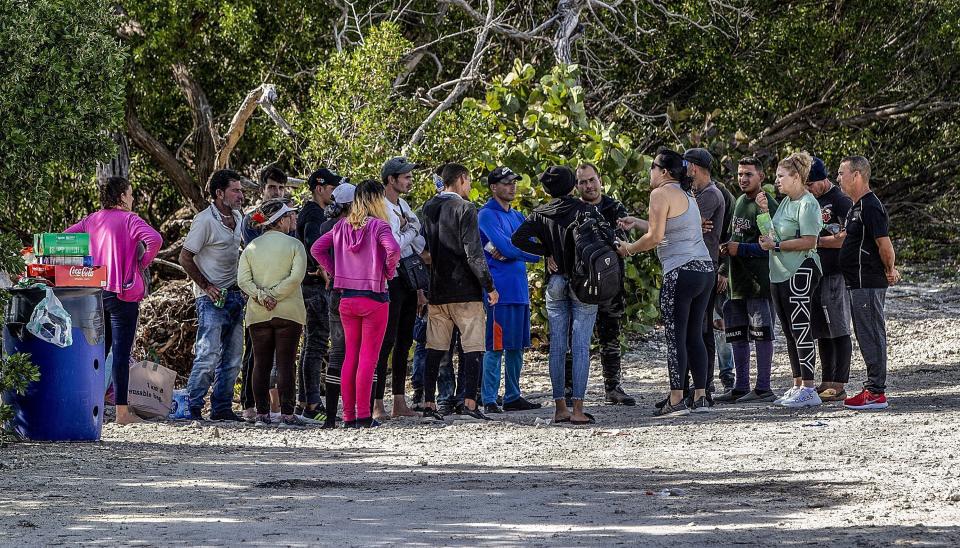 Un grupo de migrantes cubanos se reúne cerca de un camino en la isla Duck Key el lunes 2 de enero de 2023, en los Cayos de Florida. (Pedro Portal/Miami Herald vía AP)