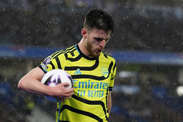 Declan Rice looks down holding a football