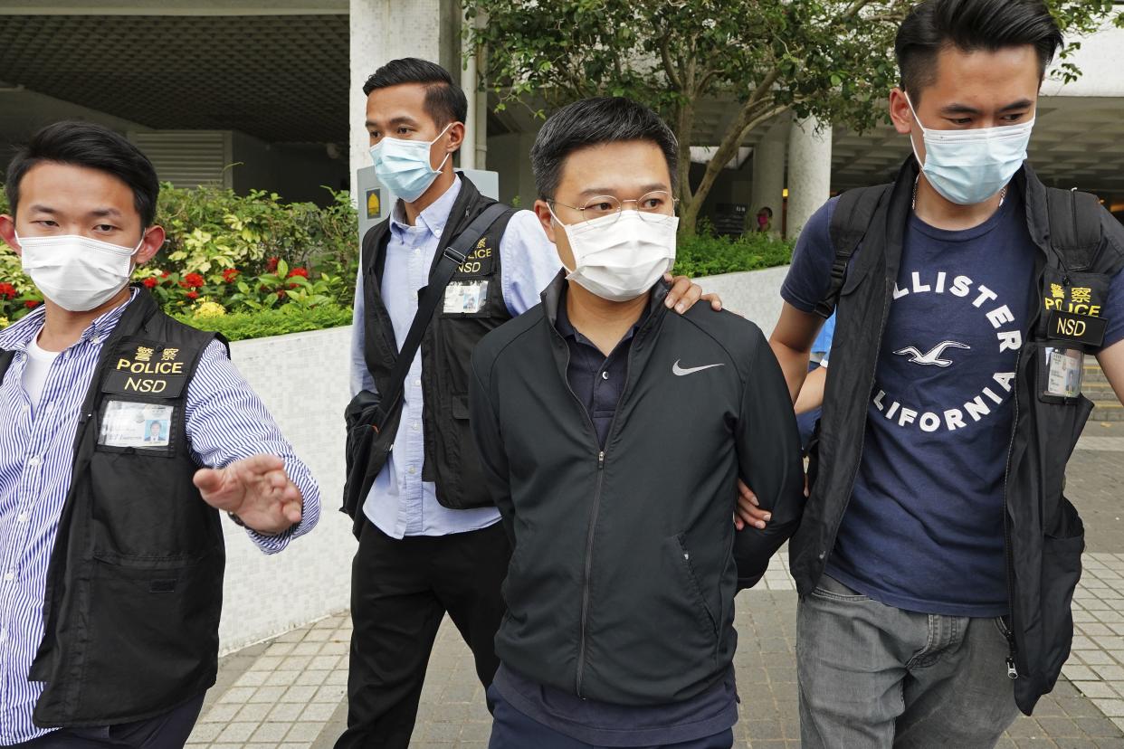 Ryan Law, second from right, Apple Daily's chief editor, is arrested by police officers in Hong Kong on Thursday.