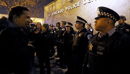 A demonstrator faces a line of police in front of the Chicago Police Department during protests in Chicago, Illinois November 24, 2015 reacting to the release of a police video of the 2014 shooting of a black teenager, Laquan McDonald, by a white policeman, Jason Van Dyke. Van Dyke was charged with murder in the incident. REUTERS/Jim Young