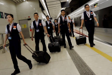 Train attendants walk at the at West Kowloon Terminus at the first day of service of the Hong Kong Section of the Guangzhou-Shenzhen-Hong Kong Express Rail Link, in Hong Kong, China September 23, 2018. REUTERS/Tyrone Siu