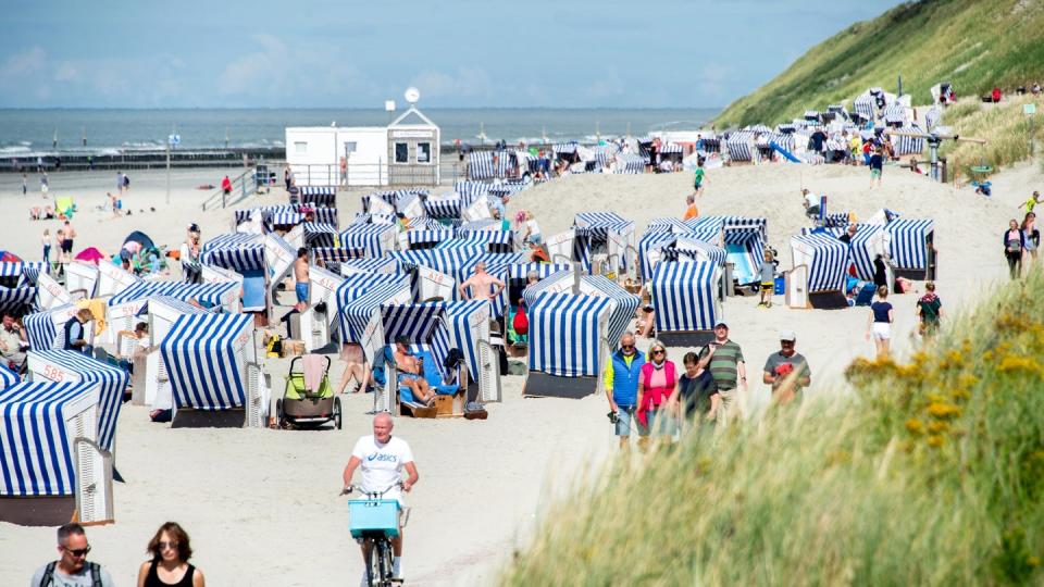 Urlaubsgäste sitzen bei sonnigem Wetter in ihren Strandkörben am Nordstrand der Insel Norderney.