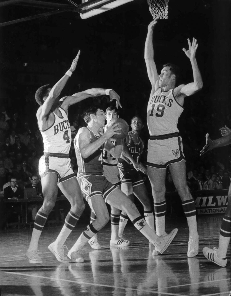 Chicago's Jerry Sloan is stopped by Milwaukee's Dick Cunningham (19) and Greg Smith (4) as he tries to drive for a basket.