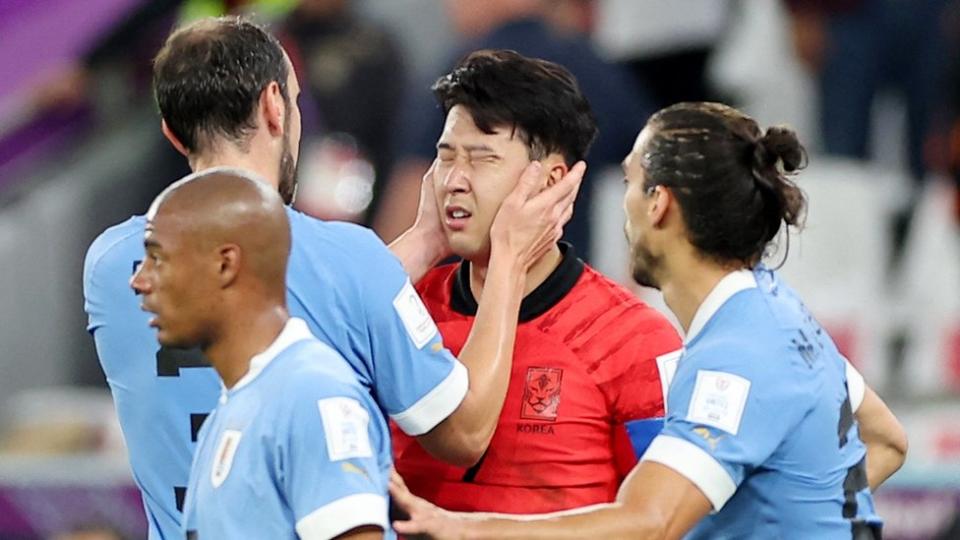 El capit&#xe1;n de la selecci&#xf3;n uruguaya, Diego God&#xed;n, toma con sus manos el rostro del futbolista surcoreano Son Heung-min.