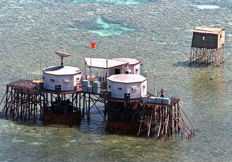 This file photo taken April 1, 1995 shows the Chinese national flag flying above octagonal structures built on stilts in the Mischief Reef in the disputed Spratly Islands. A handful of marines living on a World War II-era ship that is grounded on a remote, tiny reef is the Philippines' last line of defence against China's efforts to control most of the South China Sea