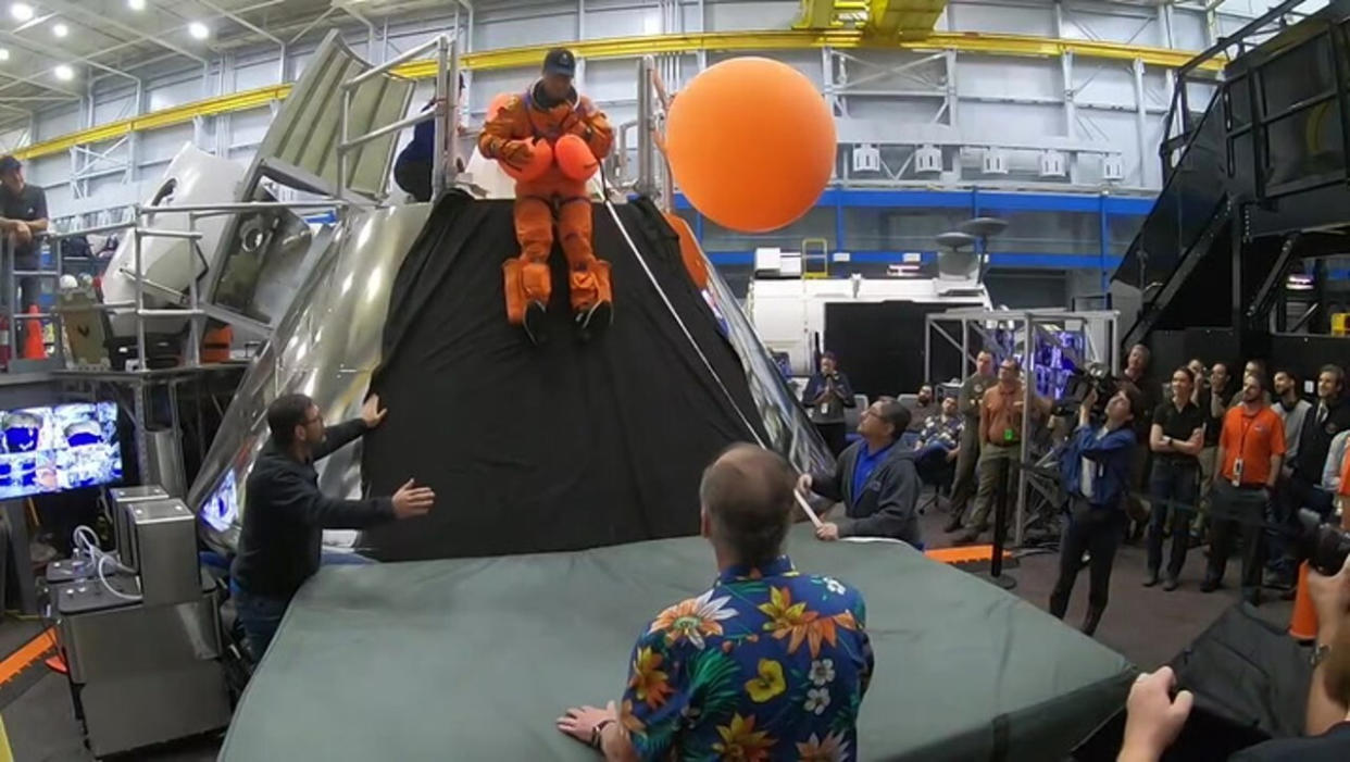  NASA Artemis 2 moon commander Reid Wiseman slides away from a mock Orion spacecraft during emergency egress training, in a video released on Dec. 18, 2023. 