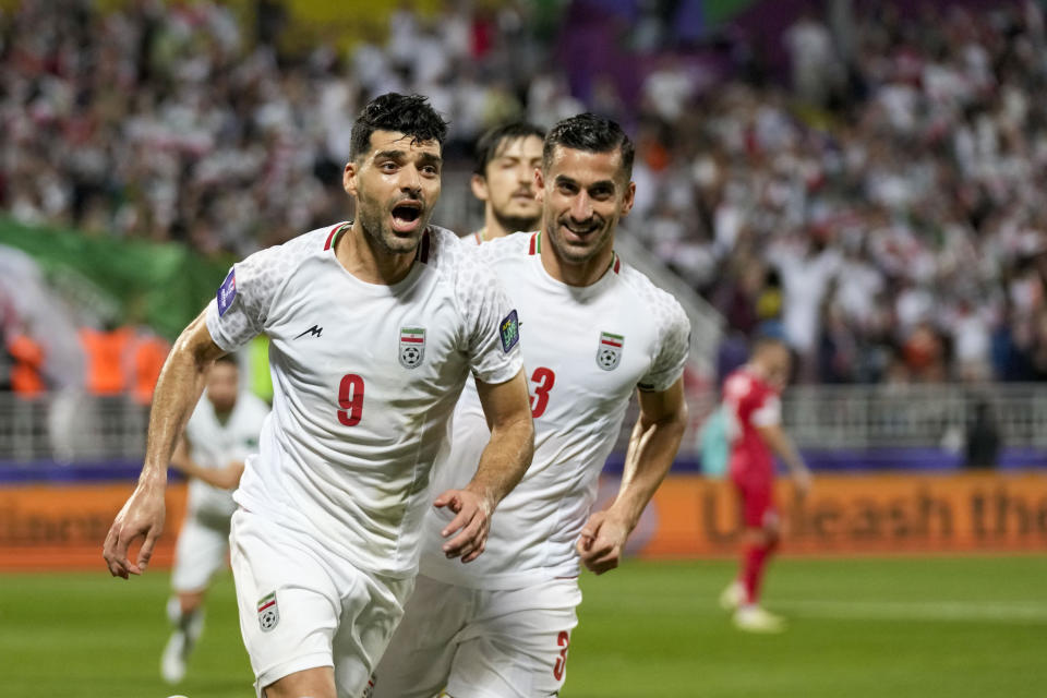 Iran's Mehdi Taremi, front, celebrates with teammates after scoring his side's opening goal from a penalty spot during the Asian Cup Round of 16 soccer match between Iran and Syria, at Abdullah Bin Khalifa Stadium in Doha, Qatar, Wednesday, Jan. 31, 2024. (AP Photo/Aijaz Rahi)