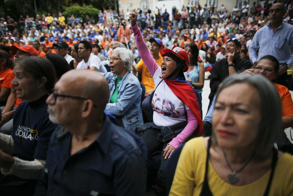 A woman screams in support of opposition leader and self-proclaimed interim President Juan Guaidó during a citizen assembly held at a square in the neighborhood of El Paradiso in Caracas, Venezuela, Monday, Sept. 30, 2019. On Monday, Guaidó came out in defense of the Colombian government claim that Colombian guerrilla troops are operating in Venezuela, and accused Venezuelan President Nicolas Maduro of supporting them. (AP Photo/Ariana Cubillos)