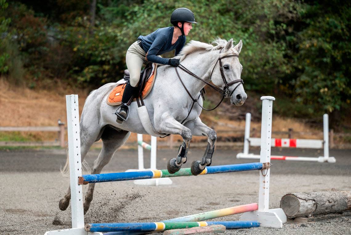 Emerald Ridge High School sophomore Emily Bingham practices jumps with her horse, Q It Up, at Signature West Farms LLC in Spanaway, Wash. on Sept. 22, 2022. Bingham was nominated by the Washington State Hunter Jumper Association for the Marshall & Sterling Insurance/USHJA National Championships, a competition for riders in the country to earn national titles.