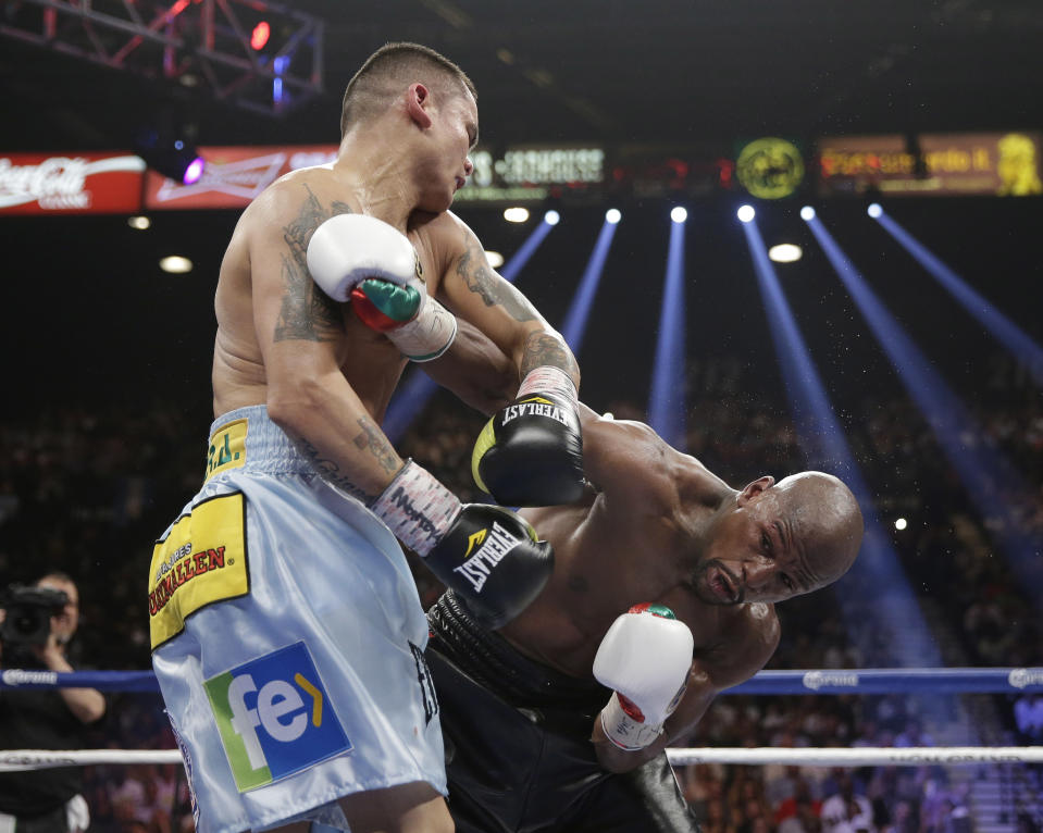 Marcos Maidana, left, from Argentina, trades punches with Floyd Mayweather Jr. in their WBC-WBA welterweight title boxing fight Saturday, May 3, 2014, in Las Vegas. (AP Photo/Isaac Brekken)