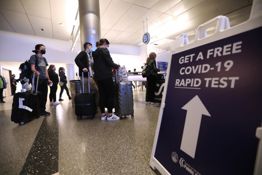 LOS ANGELES, CA - DECEMBER 3, 2021 - Arriving travelers line up to get a free COVID-19 Rapid Test at the Tom Bradley International Terminal at Los Angeles International Airport Friday, December 3, 2021. In partnership with the state and U.S. Centers for Disease Control and Prevention, the county set up a free rapid testing site for arriving passengers. They were also gave those testing negative a kit they can use to test themselves again three to five days later, in line with CDC recommendations for international travelers coming to the U.S., regardless of vaccination status. Dr. Barbara Ferrer, director of L.A. County Department of Health, was on hand trying to direct arriving passengers to take a free COVID-19 test. (Genaro Molina / Los Angeles Times)