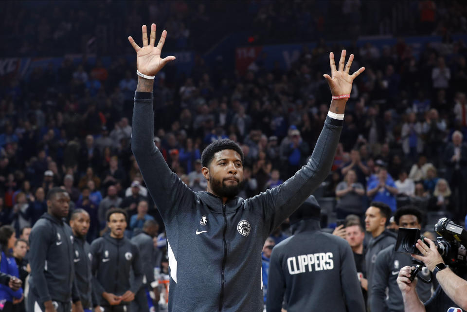 Los Angeles Clippers forward Paul George waves to Oklahoma City Thunder fans during introductions before an NBA basketball game Sunday, Dec. 22, 2019, in Oklahoma City. (AP Photo/Alonzo Adams)