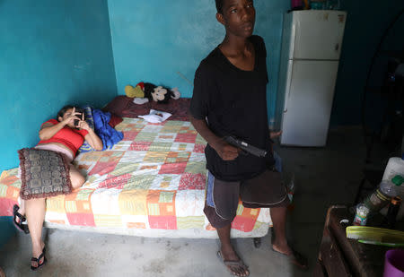 A Barrio-18 gang member holds a gun in a house in San Pedro Sula, Honduras, September 20, 2018. REUTERS/Goran Tomasevic