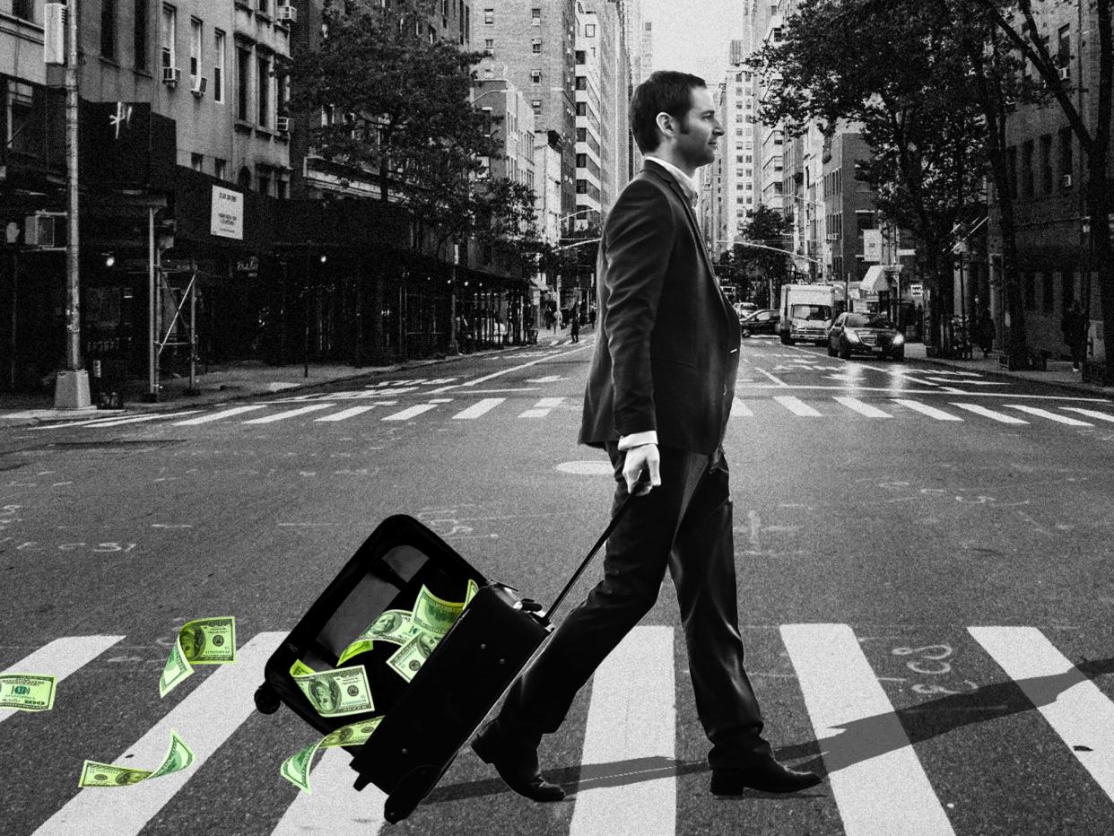 A man crossing the street with money falling out of his suitcase