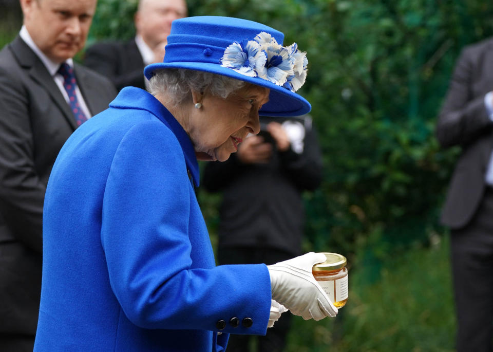 Britain's Queen Elizabeth II receives a gift of a jar of honey during a visit to The Childrens Wood Project in Glasgow on June 30, 2021, as part of her traditional trip to Scotland for Holyrood Week. (Photo by Andrew Milligan / POOL / AFP) (Photo by ANDREW MILLIGAN/POOL/AFP via Getty Images)