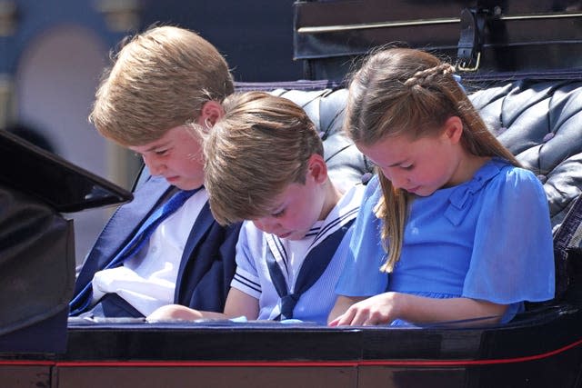 Prince George (left), Prince Louis and Princess Charlotte bow their heads as they receive a salute as the Royal Procession returns to Buckingham Palace after the Trooping the Colour ceremony on Thursday