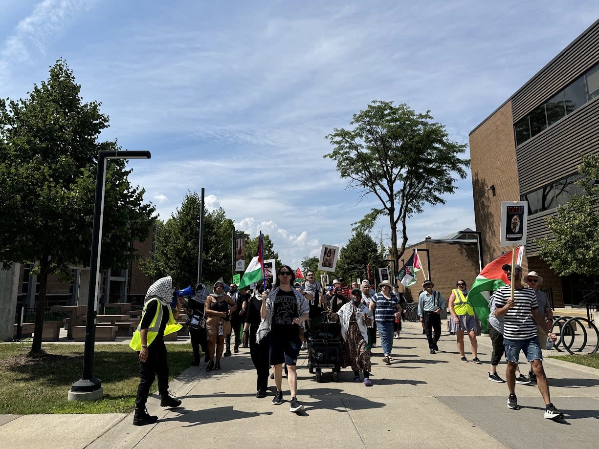Protesters at the University of Windsor marched around campus on Monday, July 8, 2024. They say they have come up with a deal with the university to end the encampment but are waiting for the university to sign.  (Kathleen Saylors/CBC - image credit)