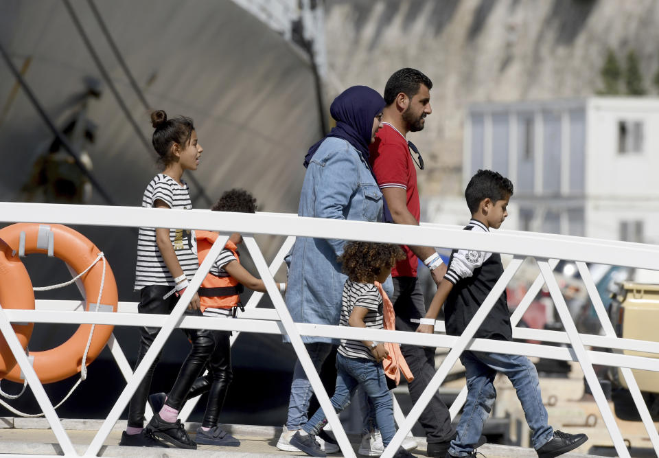 A family disembarks from a Maltese naval vessel in the port of La Valletta in Malta after being transferred from a humanitarian ship which rescued them at sea over a week ago, Sunday, Sept. 30, 2018. The Maltese government said Sunday that the migrants would be then transferred in the coming days to the four countries agreeing to accept them: France, Germany, Spain and Portugal. (AP Photo/Jonathan Borg)