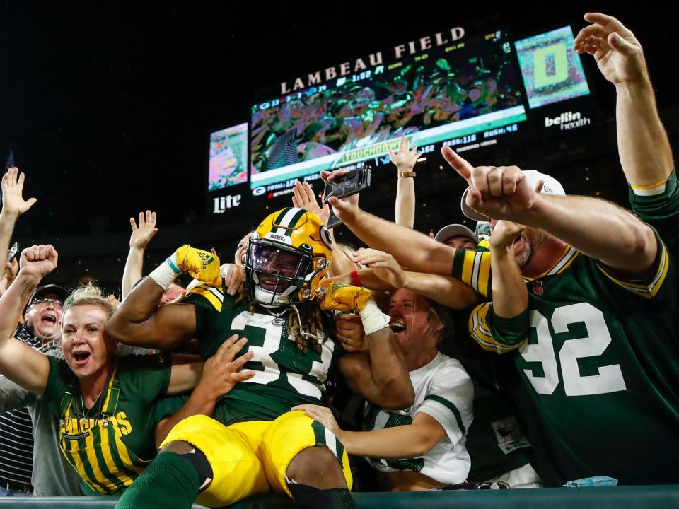 Aaron Jones celebrates with a Lambeau Leap.