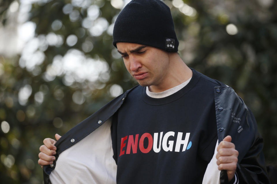 21-year-old Alexander Voneiff of Alexandria, Virginia, cries as he shows marchers his "Enough" shirt.