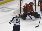 Dec 14, 2018; Chicago, IL, USA; Winnipeg Jets center Mark Scheifele (55) scores the game winning goal past Chicago Blackhawks goaltender Corey Crawford (50) during the overtime period at United Center. Mandatory Credit: David Banks-USA TODAY Sports